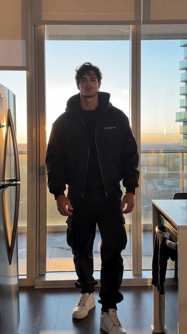 Model in a black jacket by a sunset window, from the Vanta apparel demo ad
